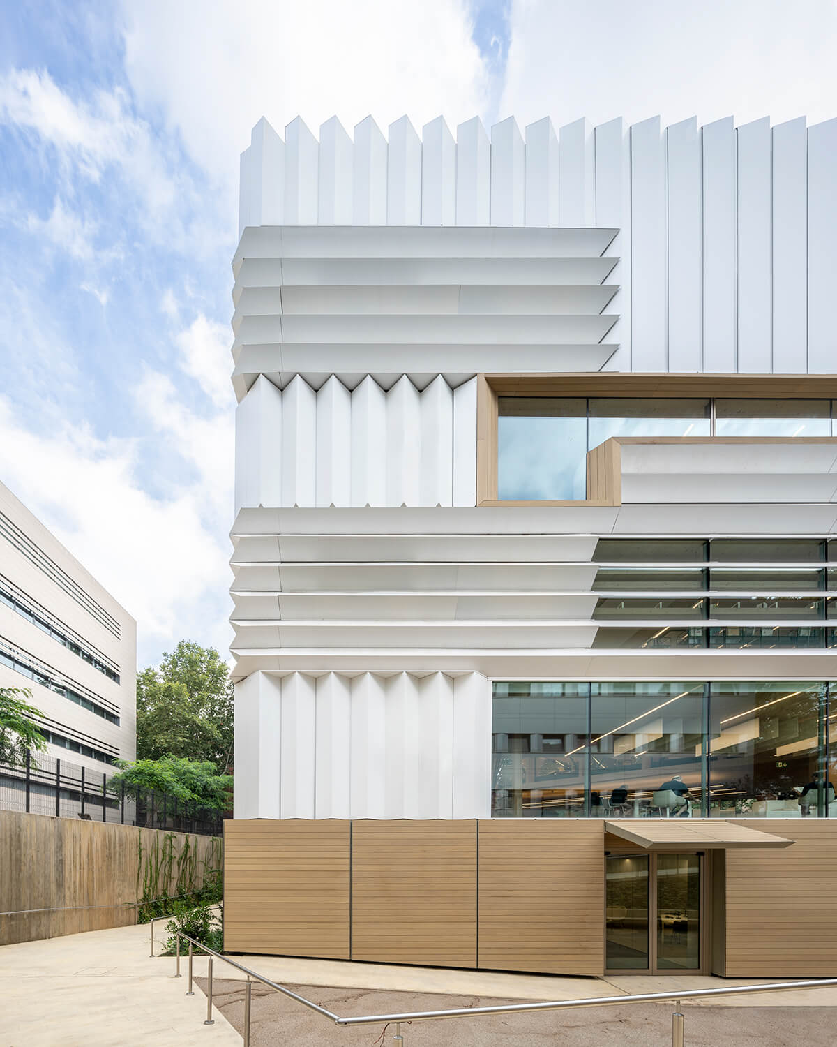 The facade of the building, a mosaic of folded white fiberglass panels.